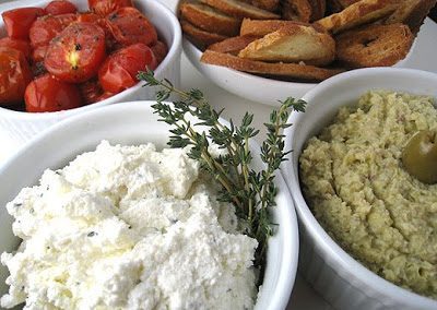 HERBED RICOTTA WITH ROASTED TOMATOES AND ARTICHOKE SPREAD AND CROSTINI